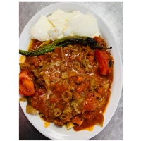 stukjes turks brood met vlees, yoghurtsaus, tomatensaus en gesmolten roomboter