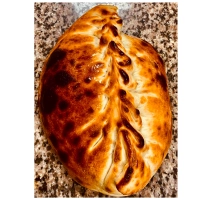 Dichtgevouwen pizza met kipfilet, ui, paprika en champignons